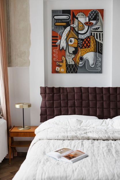 Modern bedroom with a bed, nightstand, and abstract artwork on the wall.