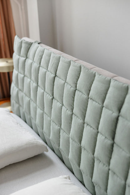 Close-up of a quilted headboard with a neutral background